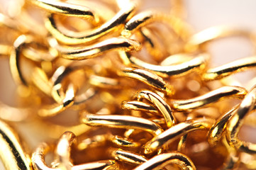Golden chain links  close-up full screen. Golden background. Conceptual photo. Macro