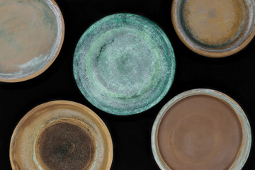 Background surface of various colors and dirty clay plates for plants and isolated on black background
