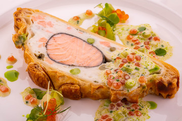 Coulibiac from a trout and a halibut, is served with the Champagne sauce and red caviar with greens