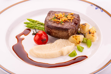 Chateaubriand from beef, a celery, an asparagus, the Porto sauce and the crackling onions