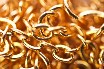 Golden chain links  close-up full screen. Golden background. Conceptual photo. Macro