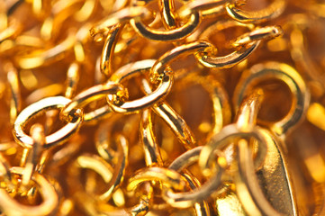 Golden chain links  close-up full screen. Golden background. Conceptual photo. Macro
