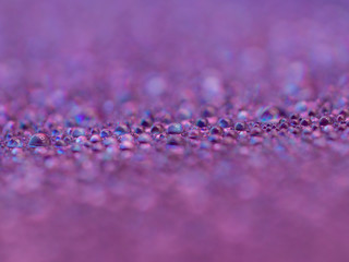 Close up water drop blurred purple color background. Bokeh drop with purple color is abstract background.