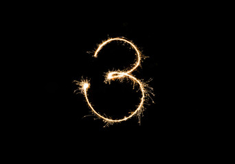 Numbers 3 or three Sparkler firework light isolated on black background