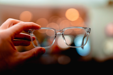 A pair of glasses with yellow bokeh in the background