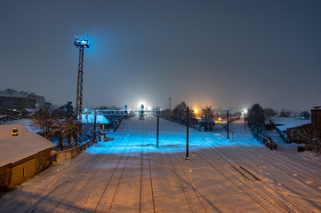 Railway tracks covered with snow at night