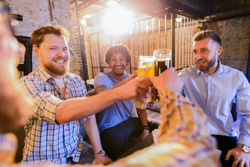 Group of man sitting in a bar with glasses full of beer in front of them. Sitting and having fun.