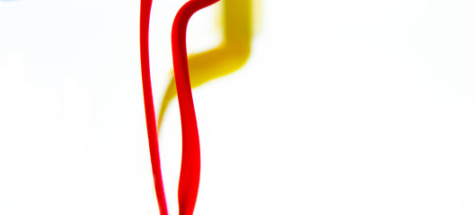 Colors dropped into liquid and photographed while in motion on white background. Color drop. Selective focus.