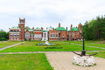 Fototapeta premium Sheremetev castle palace and park ensemble in the village of Yurino on the bank of the Volga, combination of different architectural styles in one building. Cloudy weather at the beginning of summer.