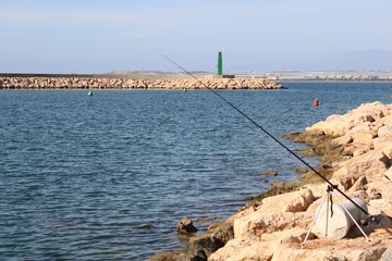 Fototapeta premium Stone jetty and fishing rod