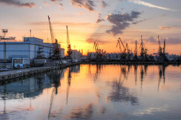 Loading grain in the port. Evening panoramic view of the port, cranes and other port infrastructure.