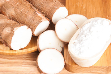 Raw cassava tuber on wooden background - Manihot esculenta