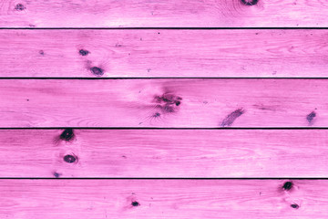 Wooden table or planks fence, pink background, texture