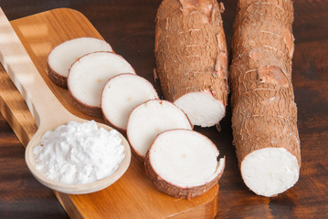 Raw cassava tuber on wooden background - Manihot esculenta