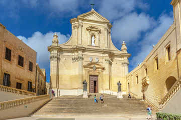 Gozo, Malta - May 16th 2019 - Tourist and locals walking in front of a catholic church in Gozo, northern of Malta