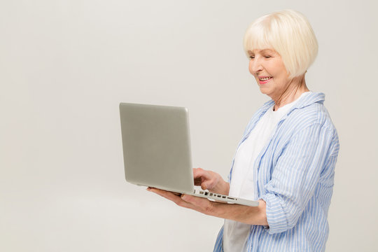 Happy Senior Woman Standing With Laptop, Isolated On White Background