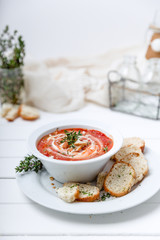 Tomato soup on white with cream and herbs. Top view, copy space