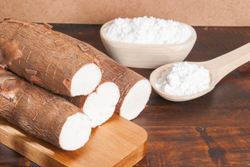 Raw cassava tuber on wooden background - Manihot esculenta
