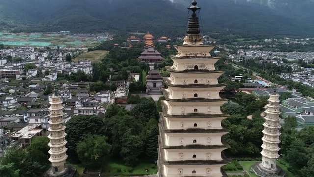 Close drone shot of historic Three Pagoda towers and rebuilt Chongsheng monastery in Dali, religion and tourism in China