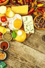 Various kinds of cheese served on wooden table. Wooden board with different kinds of delicious cheese on table. Sale of cheeses. Healthy food. Protein diet.