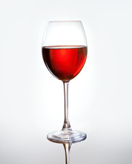 Wineglass with red wine on light gray background