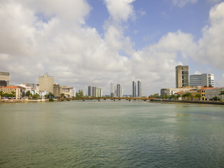 Recife, Brazil - Circa December 2018: A view of Capibaribe river with Mauricio de Nassau bridge and cityscape in the background