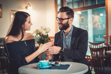 Man holding box with ring making propose to his girlfriend