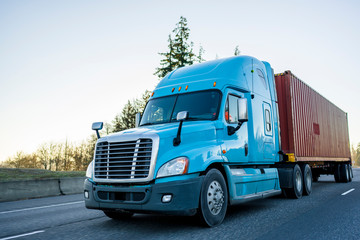 Fototapeta na wymiar Big rig long haul semi truck transporting container on the highway