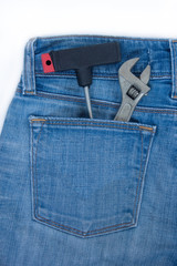 Spanner and claw hammer in the rear pocket of blue jeans.