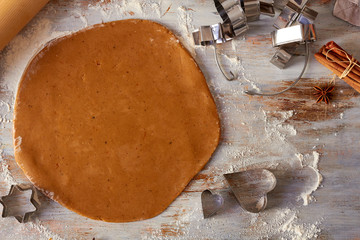 Gingerbread dough on table with cookies shapes