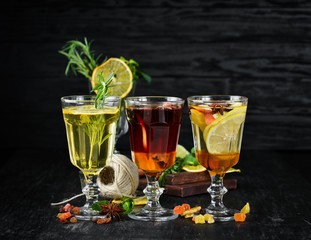 Hot winter wine cocktails. Cinnamon, cloves and honey. On a wooden background.