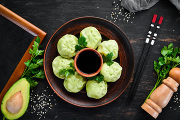 Hinkali with meat, spinach and soy sauce. On a black background. Top view. Free copy space.