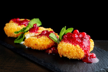 Cheese baked in batter is peppered with cranberry jam.