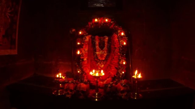 Altar of godess Kali Ma human sculls with flowers statue decorated with garland and burning candles
