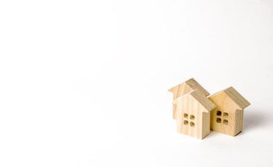 Wooden figurines of houses on a white background. Minimalism and copy space. The concept of real estate, housing, buying or selling, renting. Settlement or community. Building construction.