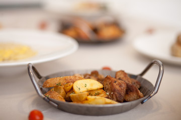 Potatoes with meat and mushrooms in the iron plate