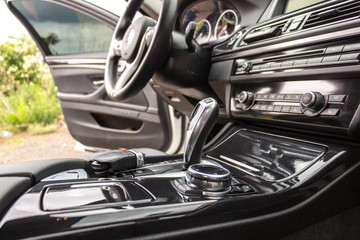 Modern car interior, steering wheel and dashboard, car navigation, automatic transmission shift selector, car climate control, comfortable vehicle