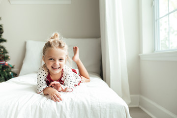 Smiling young girl lying on a bed