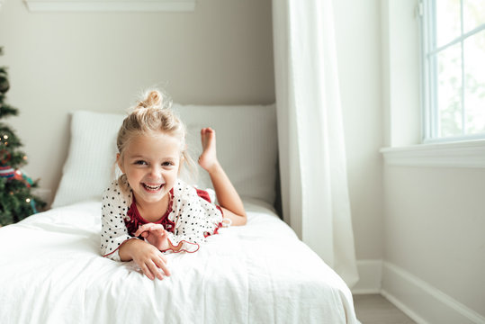 Smiling young girl lying on a bed