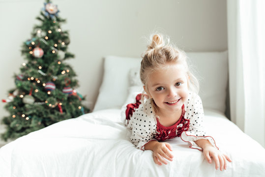 Smiling young girl lying on a bed