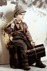 Boy sitting on luggage with books, retro shot, 50s-60s