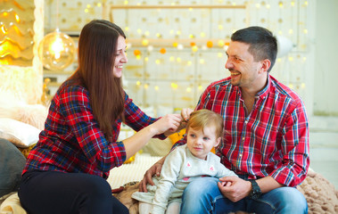 happy young parents with toddler daughter together at home