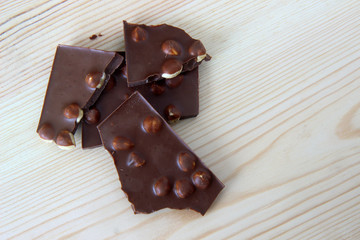 chocolate with hazelnuts on wooden background