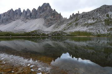 Fototapeta na wymiar Dolomite Alp mountain near the lakewith reflection in Italy