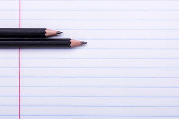 Two black graphite pencils on white sheet in line Copy space Back to school, education concept