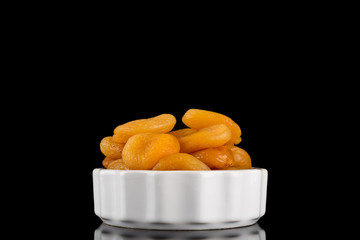 Dried Apricots in bowl Isolated on reflective black background, centered