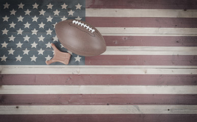 Old American football with kick tee on vintage United States wooden flag setting