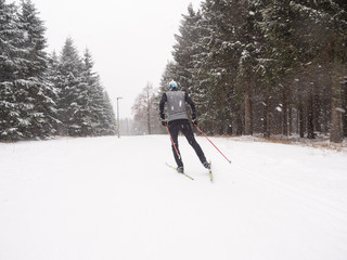 Skifahrer in Winterlandschaft auf Loipe zum Langlauf