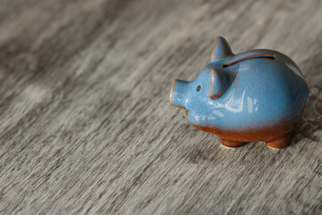 Blue piggy bank on the wooden background