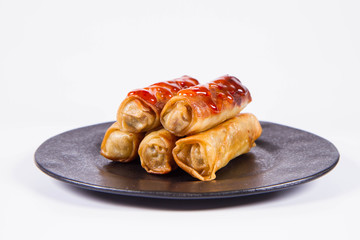 Chinese Traditional Spring rolls with sweet and sour sauce on a black plate